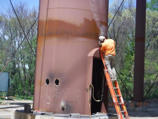 Welder finishing up attaching the access door. Welder finishing up attaching the access door.