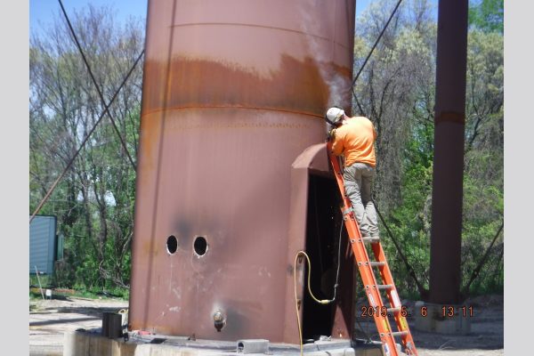 Welder finishing up attaching the access door. Welder finishing up attaching the access door.